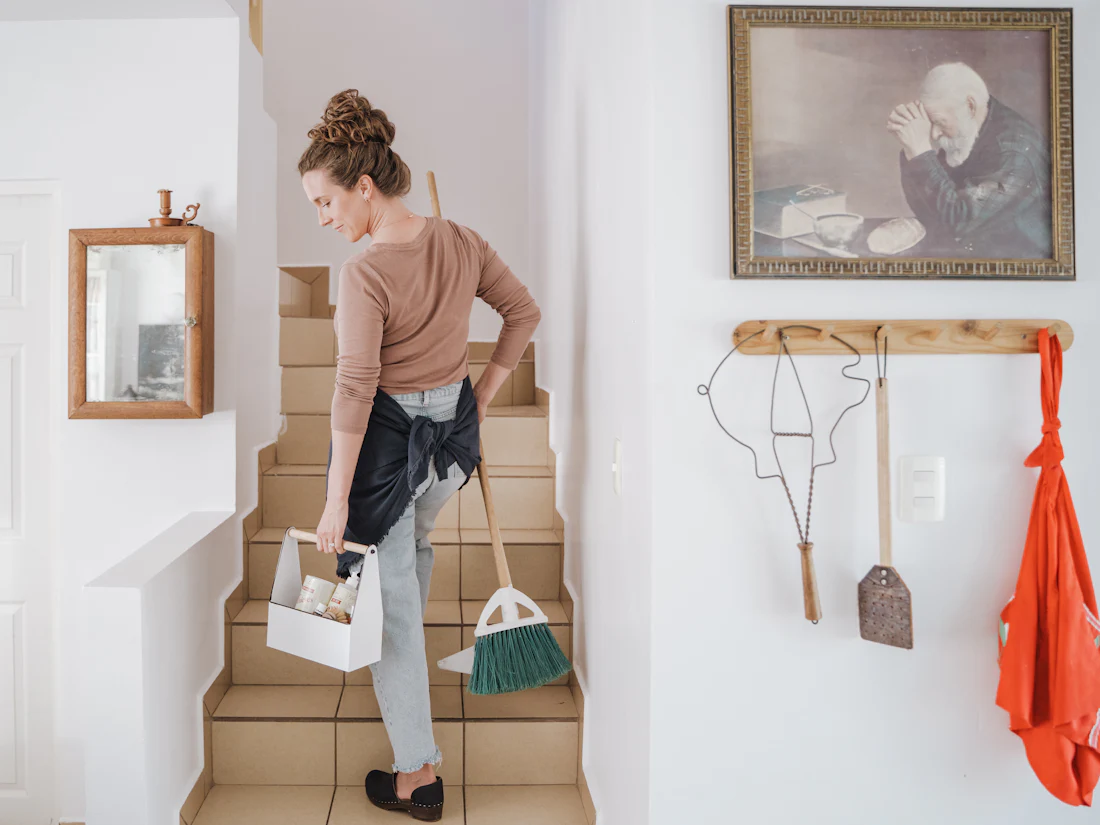A cleaner arriving for a home visit with a supply caddy