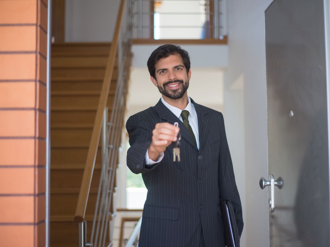 A property manager handing over a set of keys at a unit